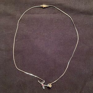 Silver flower necklace with tiny ruby.
